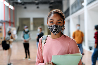 Young students in school building, with face-mask